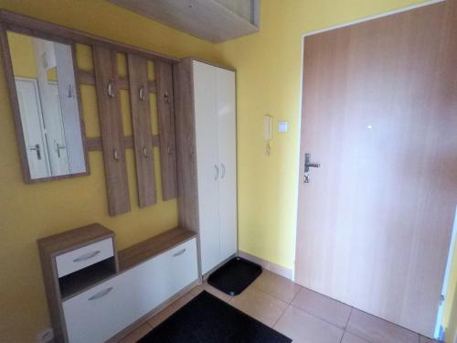 波茲南的住宿－Sunny Studio Głogowska A2 Targi，浴室设有黄色的墙壁和白色的橱柜。