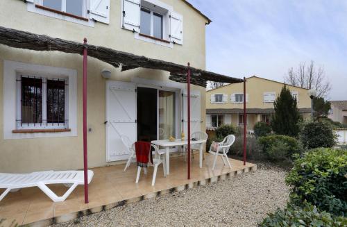 a patio with a table and chairs in front of a house at Vacancéole - Les Bastides de Fayence in Tourrettes