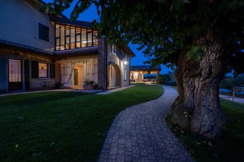 a brick driveway leading to a house with a tree at Agriturismo Le Tese in Colà di Lazise