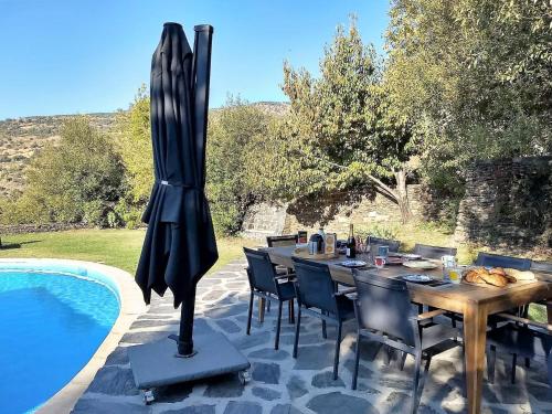 einen Esstisch und Stühle neben einem Pool in der Unterkunft Casa de Alguaztar in Bubión