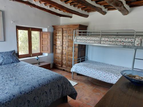 1 Schlafzimmer mit 2 Etagenbetten und einem Tisch in der Unterkunft Casa de Alguaztar in Bubión