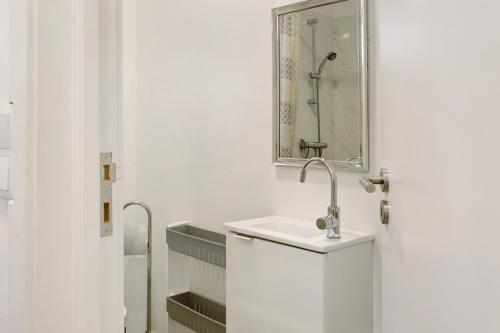 a white bathroom with a sink and a mirror at Funchal House in Funchal