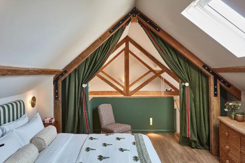 um quarto com uma cama e duas cadeiras em The Farm at Avebury em Marlborough