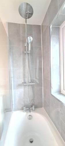 a bath tub with a shower in a bathroom at Shanti in Darlington