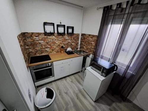 mała kuchnia ze zlewem i kuchenką mikrofalową w obiekcie HostelHollabrunn w mieście Hollabrunn