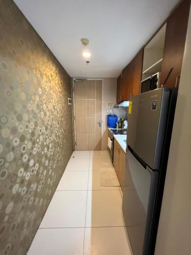 a small kitchen with a refrigerator and a tile floor at Bonel condo at Pico de Loro in Cutad