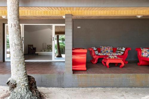 a patio with red furniture and a table and chairs at Hotel Coucoue Lodge in Assinie