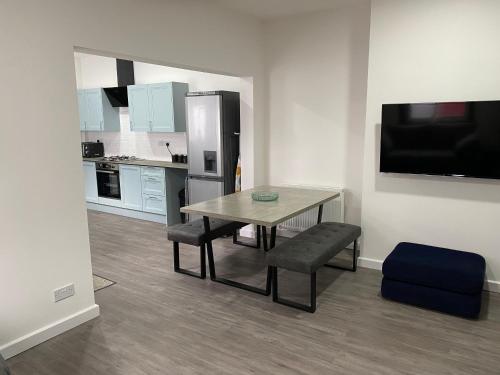 a small kitchen with a table and a refrigerator at Apex Living NE - Carnegie House 4 Bed House, FREE PARKING FREE WiFi in Ryhope