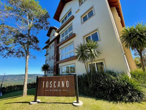 een gebouw met een bord ervoor bij Apartamentos Residencial Toscano by Achei Gramado in Gramado