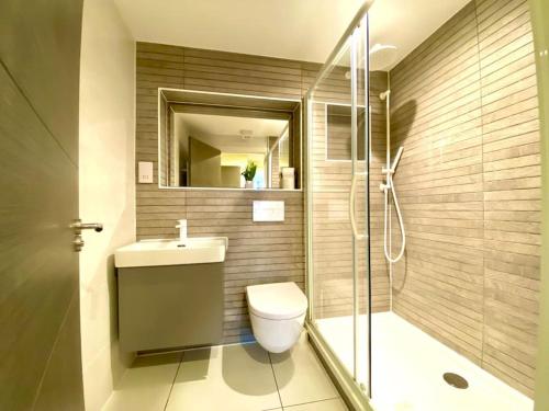 a bathroom with a toilet and a sink and a shower at Elegant Apartment - 1 Minute walk to Poole Quay - Great Location - Free Parking - Fast WiFi - Smart TV - Newly decorated - sleeps up to 2! Close to Poole & Bournemouth & Sandbanks in Poole
