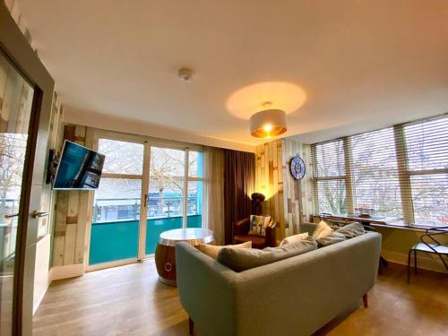 a living room with a couch and a tv at Elegant Apartment - 1 Minute walk to Poole Quay - Great Location - Free Parking - Fast WiFi - Smart TV - Newly decorated - sleeps up to 2! Close to Poole & Bournemouth & Sandbanks in Poole