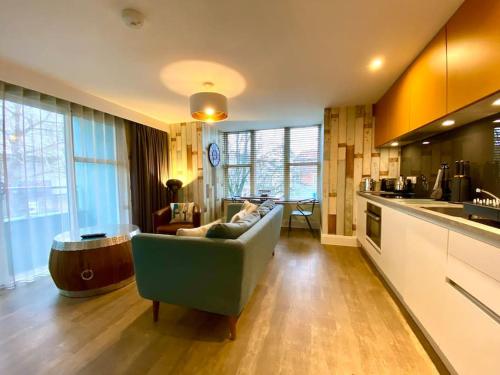 a living room with a couch and a kitchen at Elegant Apartment - 1 Minute walk to Poole Quay - Great Location - Free Parking - Fast WiFi - Smart TV - Newly decorated - sleeps up to 2! Close to Poole & Bournemouth & Sandbanks in Poole