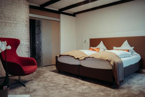 1 dormitorio con 1 cama y 1 silla roja en Hotel Krone, en Beffendorf