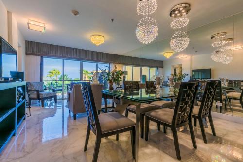 une salle à manger avec une table et des chaises en verre dans l'établissement Luxurious Beach Retreat With Best Views!, à Palm-Eagle Beach
