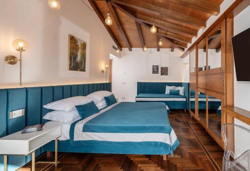 a bedroom with a blue and white bed and a couch at Villa Antiche Mura Relais in Sorrento