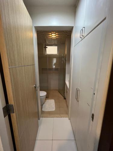 a small bathroom with a toilet and a door at Bonel condo at Pico de Loro in Cutad