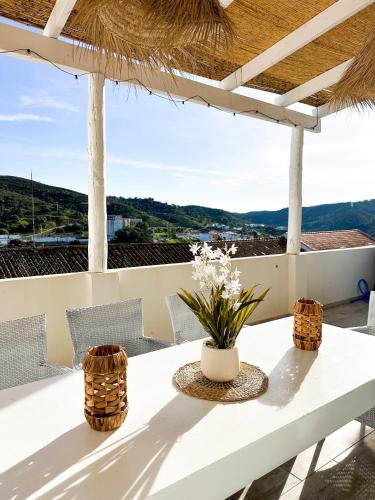a white table with chairs and flowers on a balcony at 4Cantos Alentejo in Mértola