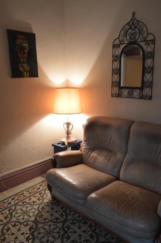 a living room with a leather couch and a lamp at Dar Omar Khayam in Tangier