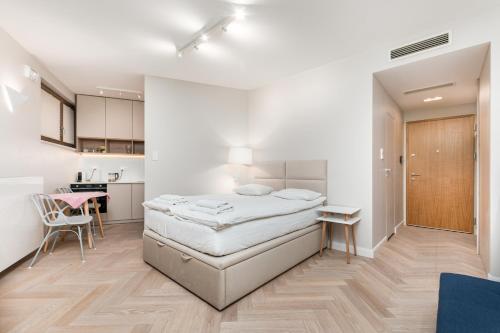 a bedroom with a bed and a desk and a kitchen at Apartament Solidarności by Your Freedom in Warsaw