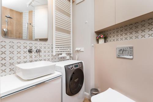 a bathroom with a washing machine and a sink at Apartament Solidarności by Your Freedom in Warsaw