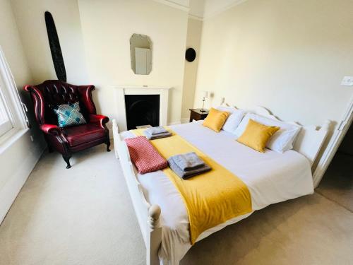 a bedroom with a large bed and a red chair at 3 Bedroom House, ST9, Ryde, Isle of Wight in Ryde