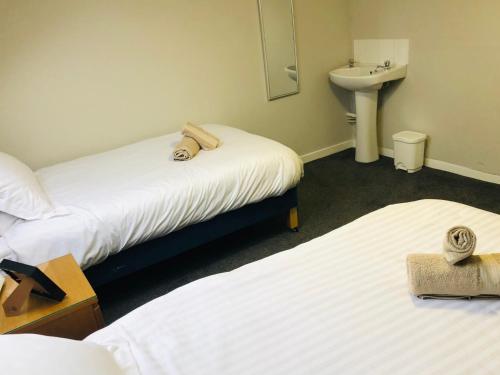 a room with two beds and a sink and a mirror at Bonnygate in Fife