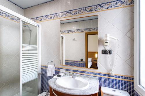 a bathroom with a sink and a shower and a mirror at Negresco Gran Via in Madrid