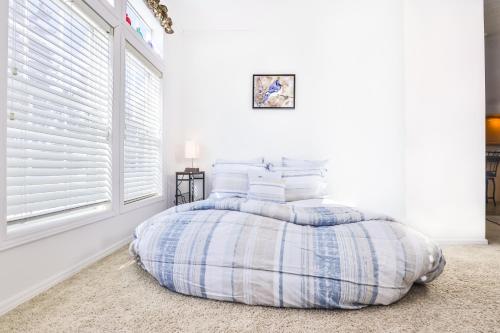 a bed in a white room with a window at Base Camp Eagle River in Eagle River