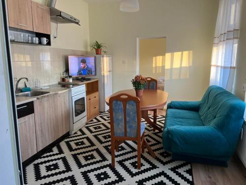 a small kitchen with a table and a blue couch at Wohnung 18 in Lutherstadt Eisleben