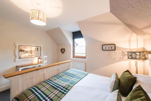 a bedroom with a bed and a window at The Old Byre with Hot Tub in Forgandenny