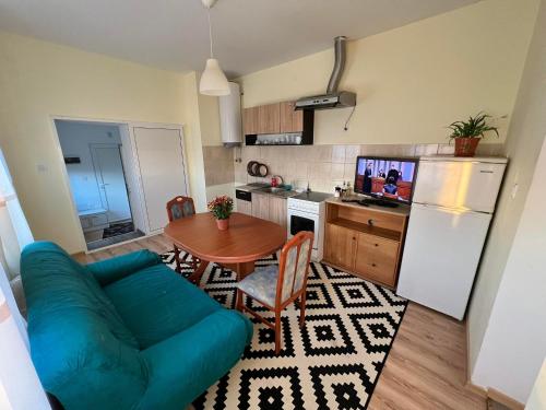 a living room with a blue couch and a kitchen at Wohnung 18 in Lutherstadt Eisleben