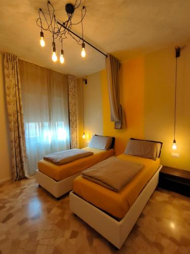 two beds in a room with yellow walls at Zeljko's luxury hostel in Vicenza