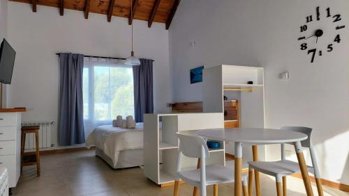 1 dormitorio con 1 cama, mesa y sillas en Estudio Pinar del Lago en San Carlos de Bariloche