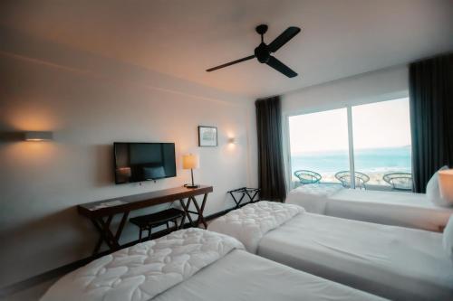 a hotel room with two beds and a television at Wyndham Tamarindo in Tamarindo