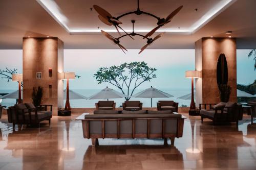 a lobby with a couch and chairs and a chandelier at Wyndham Tamarindo in Tamarindo