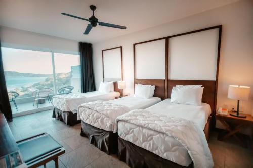 a hotel room with two beds and a balcony at Wyndham Tamarindo in Tamarindo