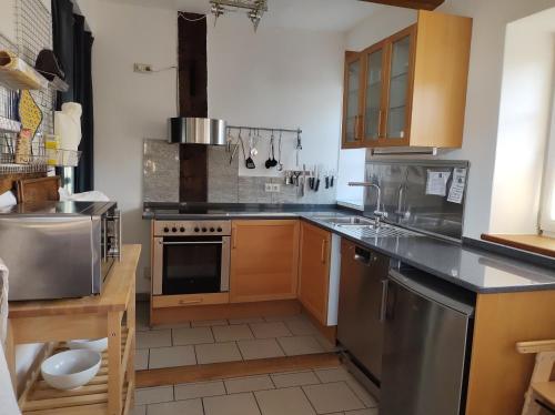 a kitchen with wooden cabinets and stainless steel appliances at Fewo Haus Patze in Betzendorf