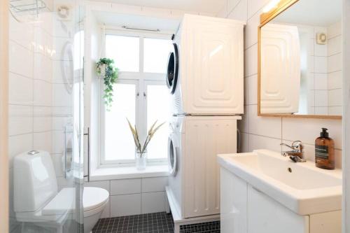 La salle de bains est pourvue d'un lavabo, de toilettes et d'une fenêtre. dans l'établissement Home away from home in Trondheim, à Trondheim