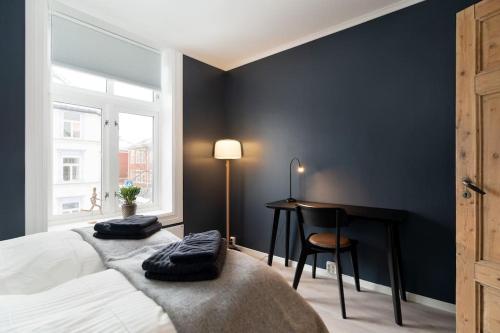 a bedroom with a bed with a desk and a chair at Home away from home in Trondheim in Trondheim