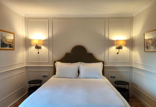 a bedroom with a large white bed with two lamps at CHATEAU DE BRINVILLE in Saint-Sauveur-sur-École