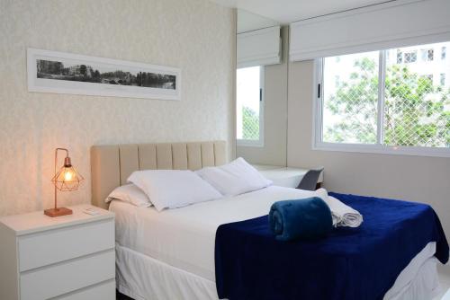 Un dormitorio con una cama con una bolsa azul. en Barra Design - Barra da Tijuca, Piscina e Conforto, en Río de Janeiro