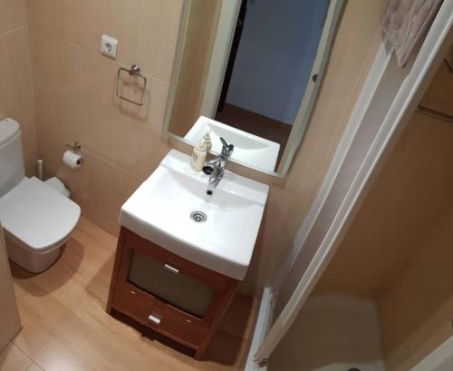 uma casa de banho com um lavatório, um WC e um espelho. em Mode's beachfront em Fuengirola