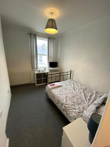 a small bedroom with a bed and a window at The Nook En-suite Room in Plymouth