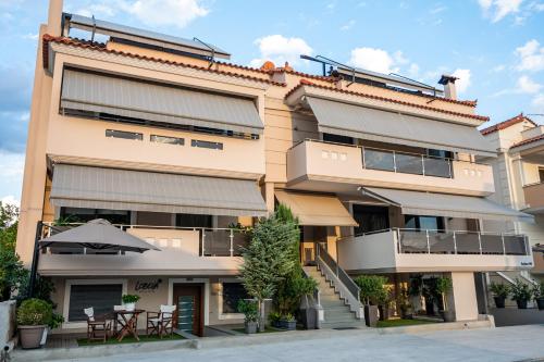 an apartment building with tables and an umbrella at Lobelia Nafplio Apartments in Nafplio