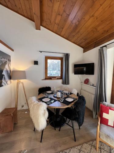 une salle à manger avec une table et des chaises noires dans l'établissement N5 Megève - Résidence de L'ours - appart 4 pers, à Megève