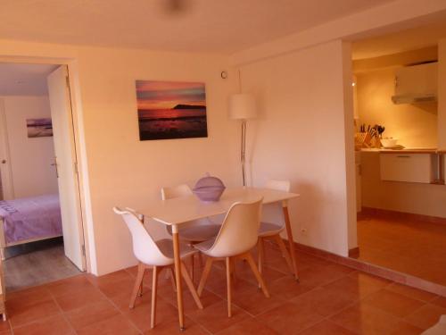 a dining room table and chairs in a room at Bas de villa jardin plein sud proche mer clim-Wifi in Saint-Mandrier-sur-Mer