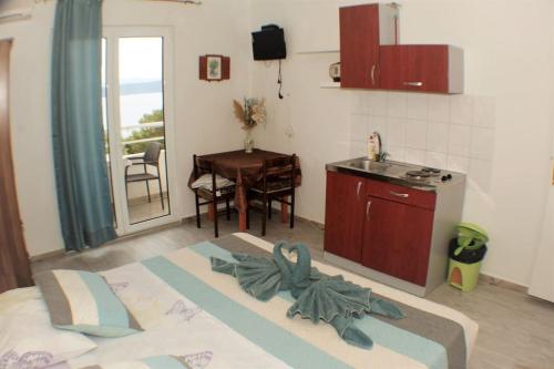 a room with a bed and a kitchen with a table at A1 tončev apartman in Igrane