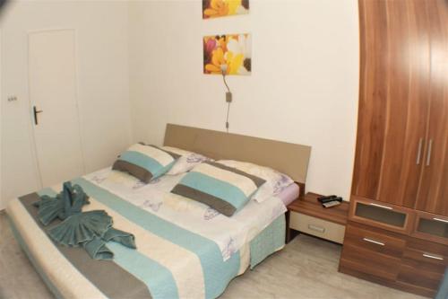 a bedroom with a bed and a wooden cabinet at A1 tončev apartman in Igrane