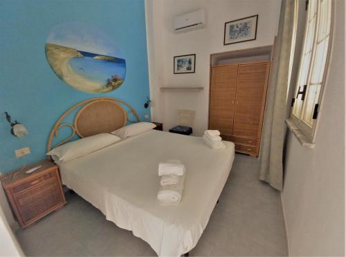 um quarto com uma grande cama branca num quarto em Case Pescatori em Lampedusa