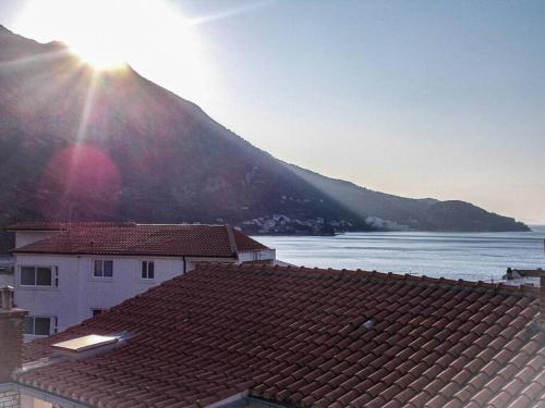 a view of a mountain with the sun rising over roofs at A1 tončev apartman in Igrane
